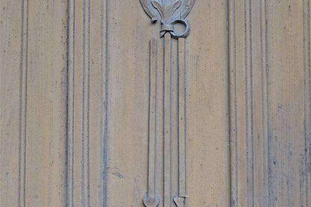 Detail dveří – reliéfní řezba vavřínového věnce se závěsy 